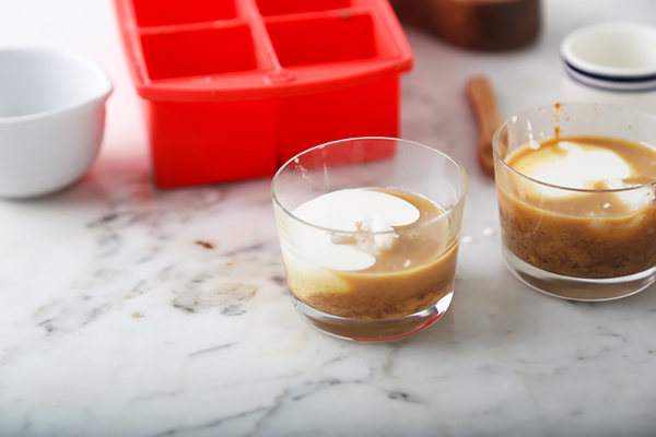 Heavy cream poured over the peanut butter and coconut oil in glass cups