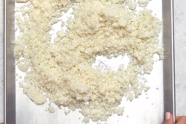 Riced cauliflower with a short-grain rice texture spread on a metal sheet pan