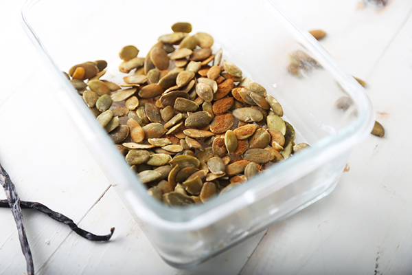 Toasted pumpkin seeds spread in a glass dish for white chocolate bark topping