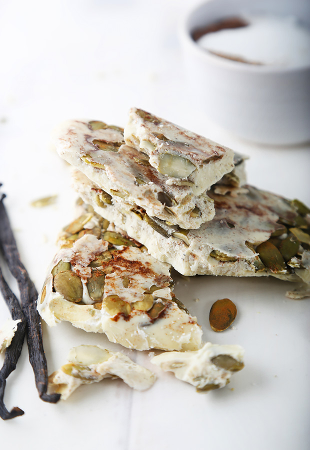 Broken pieces of white chocolate bark studded with toasted pumpkin seeds and hemp seeds