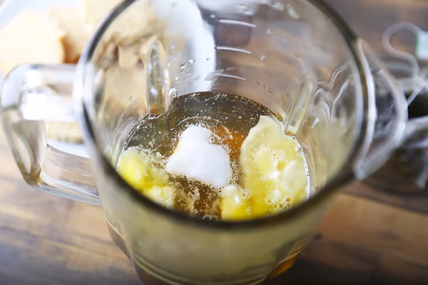 Butter and coconut oil floating in brewed green tea in a glass pitcher