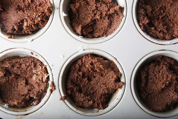 Chocolate curry cupcake batter portioned into six white cupcake molds