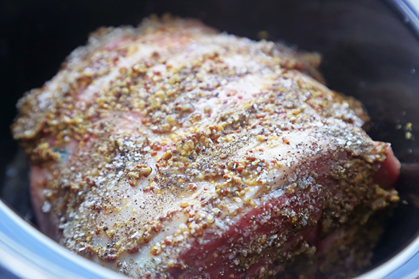 Garlic and rosemary stuffed into the slits of a mustard-rubbed lamb leg