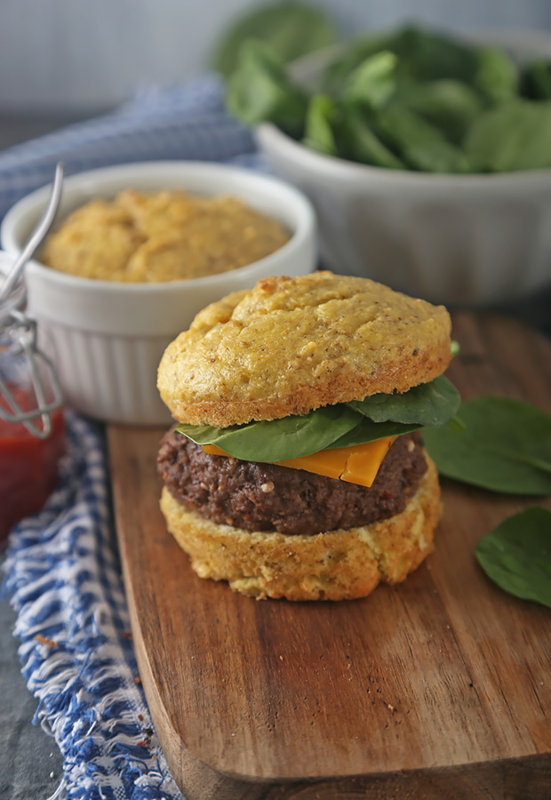 Microwave hamburger bun sliced in half with a beef patty, cheese, and spinach