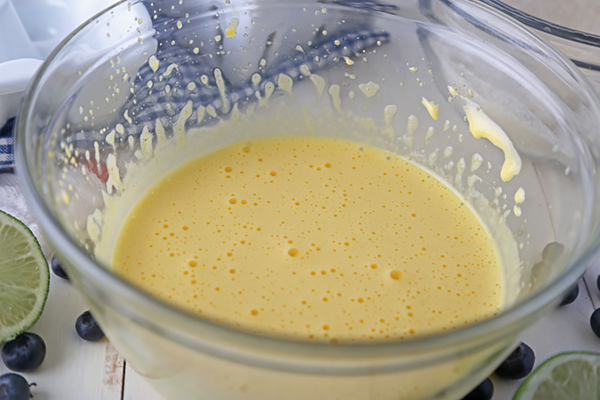 Egg yolks beaten until pale yellow and frothy in a glass mixing bowl