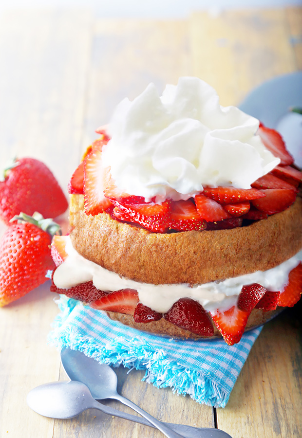 Layered strawberry shortcake stacked with whipped cream and fresh strawberry slices