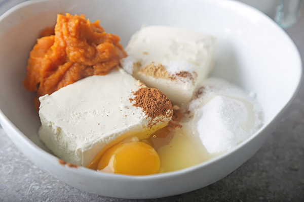 Cream cheese, pumpkin puree, egg, erythritol, and cinnamon in a white bowl
