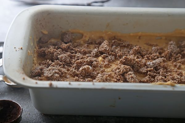 Cocoa crumb topping scattered over the pumpkin cheesecake layer before baking