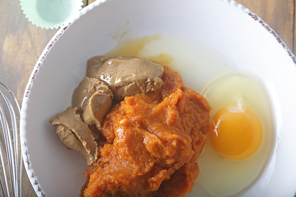 Pumpkin puree, sunflower seed butter, and a raw egg in a mixing bowl