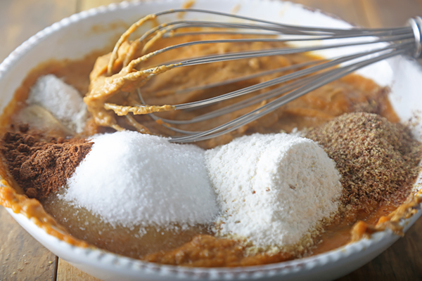 Coconut flour, flaxseed meal, erythritol, and cinnamon added to the pumpkin batter
