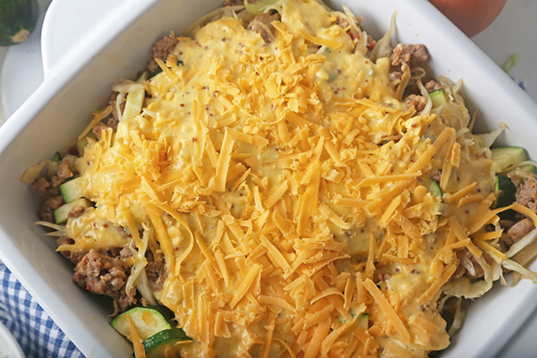 Egg custard and shredded cheddar poured over the sausage vegetables before baking