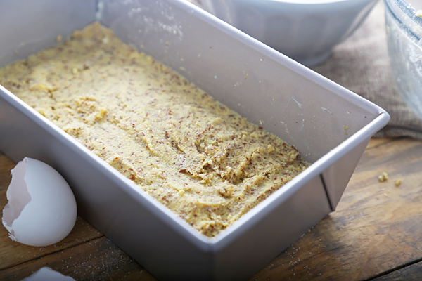 Coconut flour bread batter pressed into a greased metal loaf pan