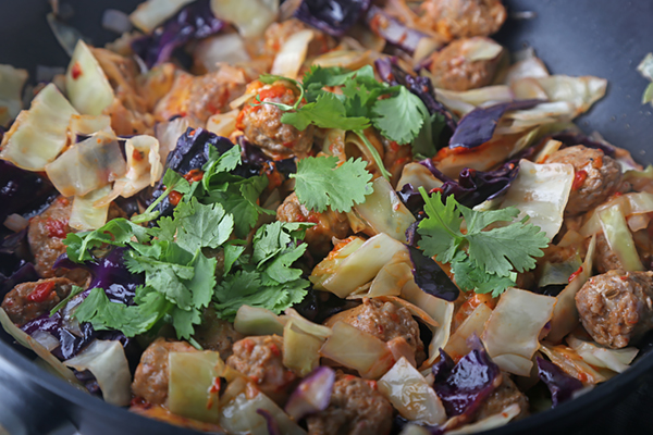Chorizo and cabbage skillet melt topped with fresh cilantro after the cheese melted
