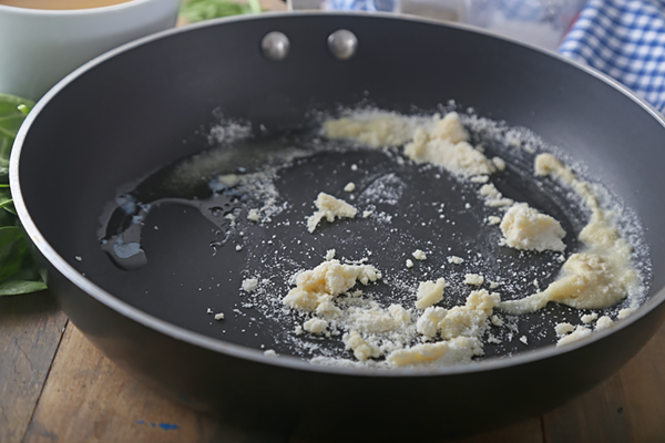 Whisking coconut flour into melted butter to form a roux in a saucepan