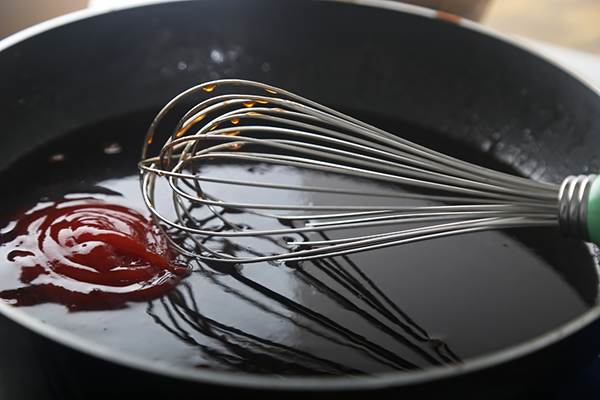 Whisking ketchup, soy sauce, apple cider vinegar, and erythritol together in a saucepan