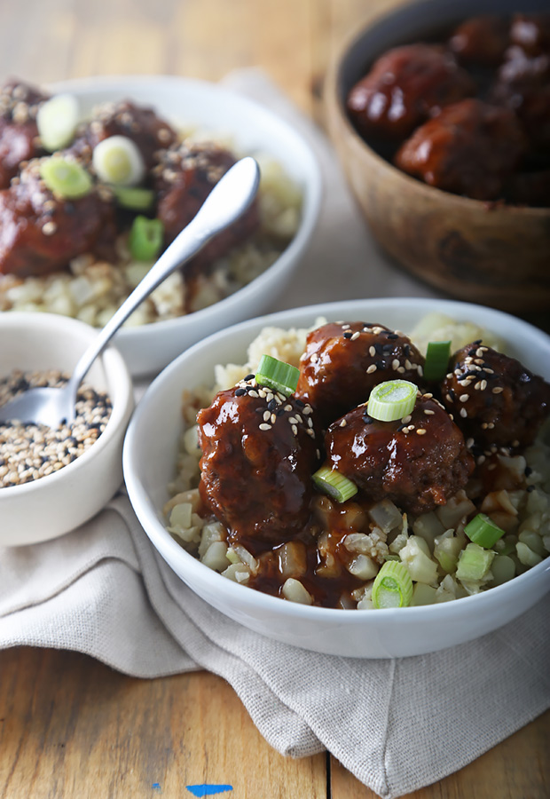 Glazed sweet and sour meatballs over cauliflower rice with sesame seeds and green onion