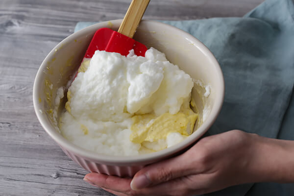 Folding egg whites into the egg yolks.