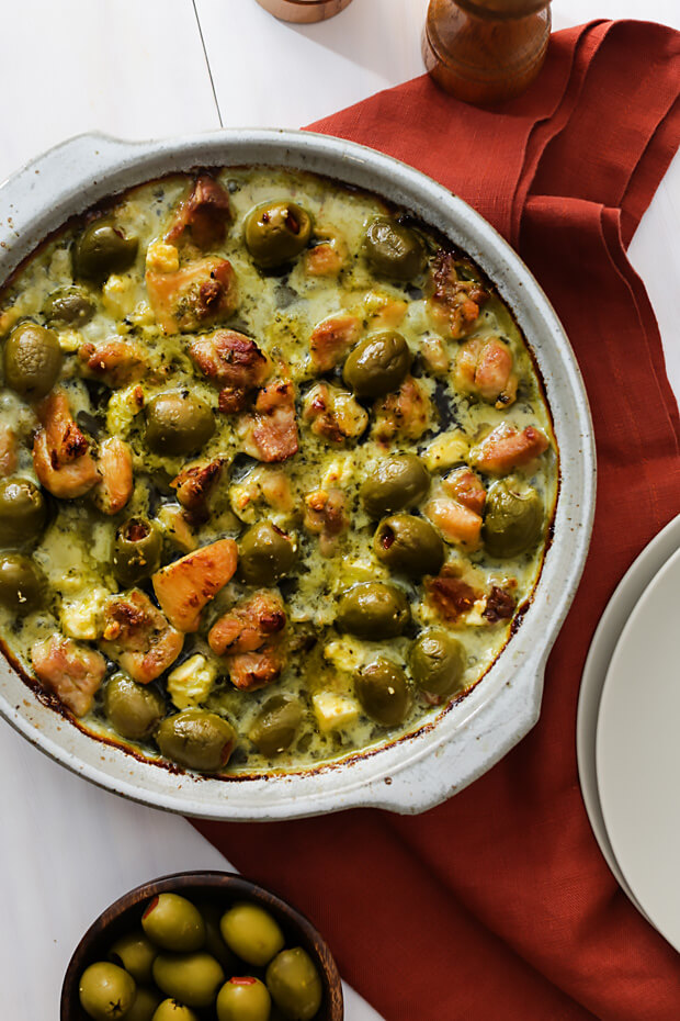 Low carb pesto chicken, feta, and olive casserole on a table.