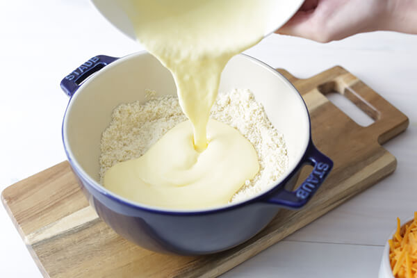 Pouring the wet ingredients into the dry ingredients.