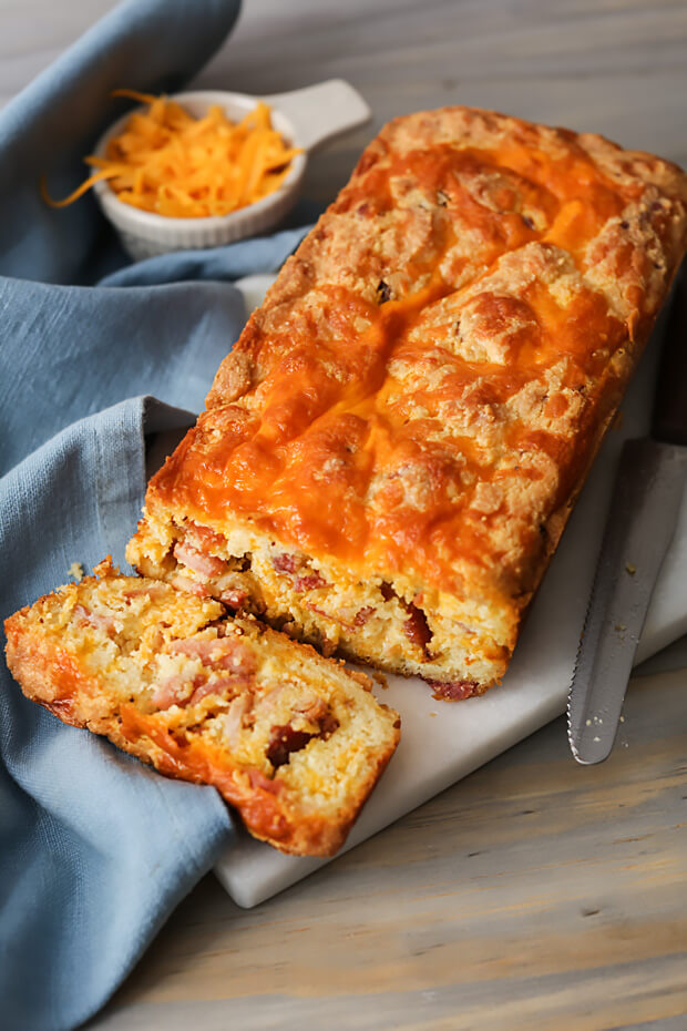Finished keto cheesy bacon bread with slice cut off the end, revealing the tasty inside!