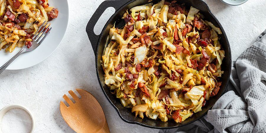Fried cabbage and bacon in a skillet
