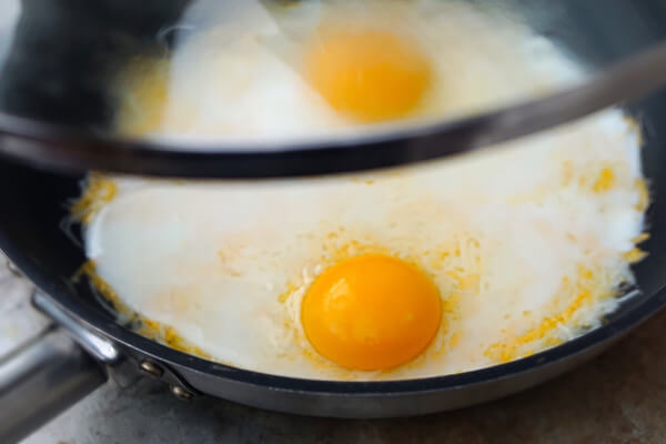 Covering eggs in a skillet.