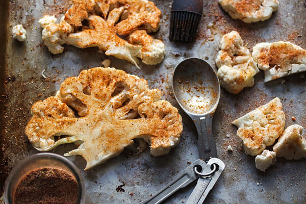 Seasoning the cauliflower steaks.