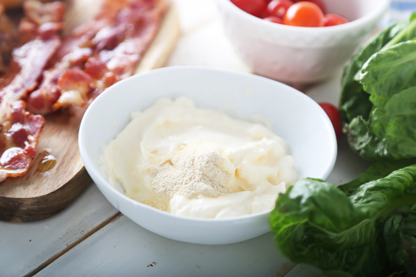 Mayonnaise with garlic powder sprinkled on top in a small shallow bowl