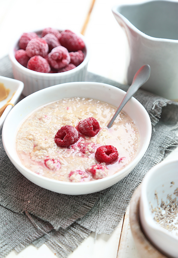 Stirring boiled water into the chia seed and peanut butter mixture with floating raspberries