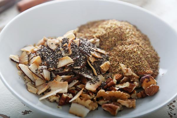 Coconut flakes, chia seeds, flaxseed meal, and chopped walnuts measured into a large bowl