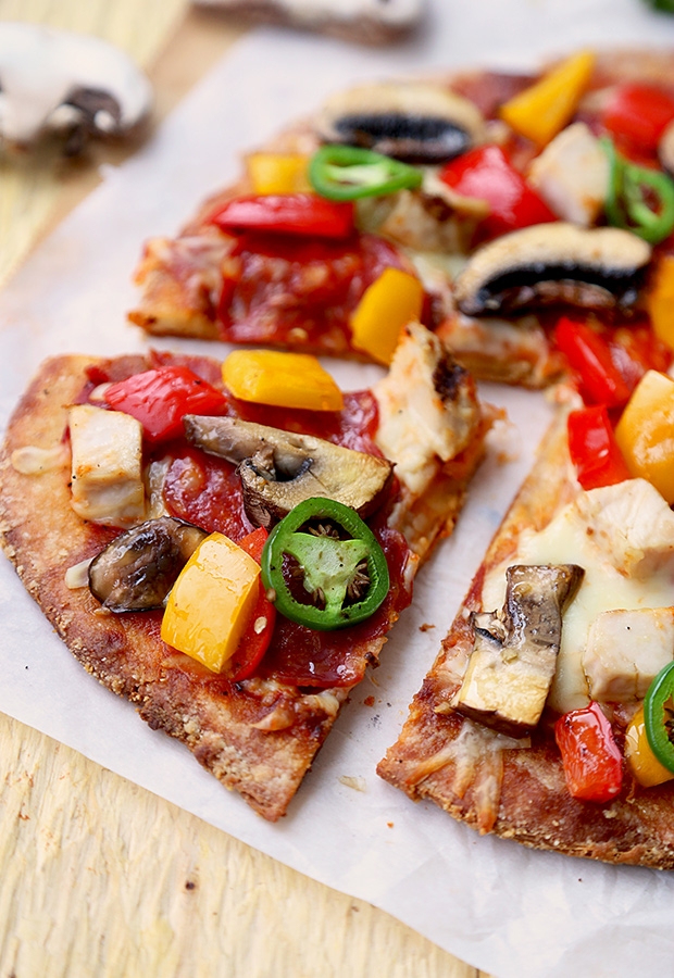 Cut stuffed crust pizza topped with chicken, bell peppers, mushrooms, and jalapeno