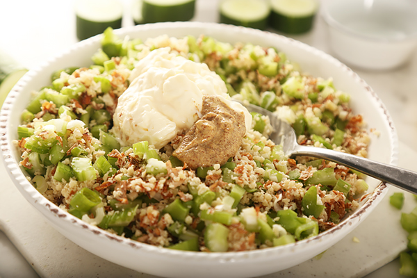 Chopped almonds mixed with diced celery, green onion, mayonnaise, and dijon mustard in a bowl