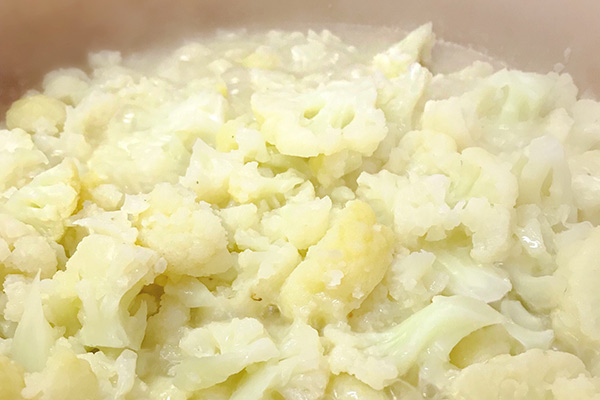 Cauliflower simmering in a small amount of water until tender