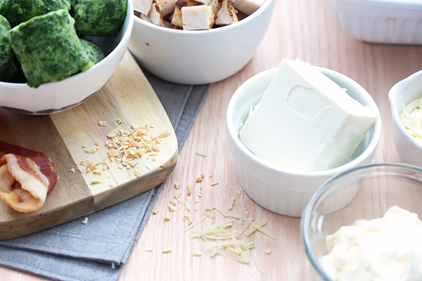Frozen spinach, diced chicken, cream cheese, sour cream, parmesan, and bacon in small bowls