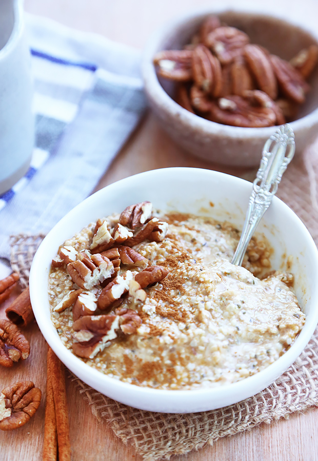 Pumpkin spice overnight oats topped with pecans and cinnamon in a white bowl