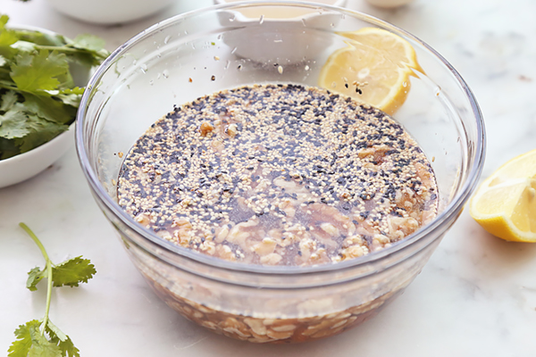 Walnuts, almonds, and sesame seeds soaking in water in a glass bowl