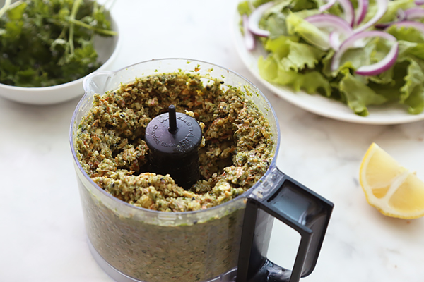 Thick green falafel mixture pulsed with soaked nuts in the food processor