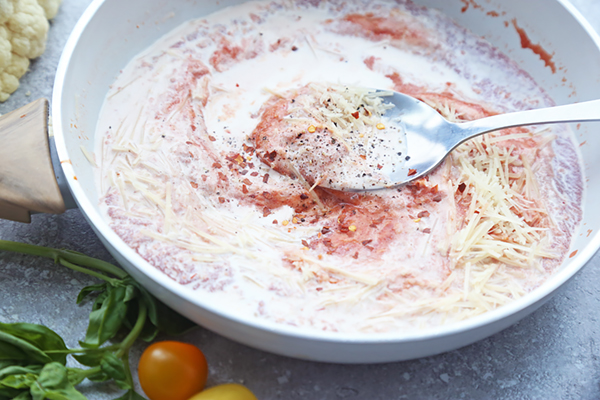 Tomato sauce, heavy cream, grated parmesan, and red pepper flakes stirred together in a saucepan