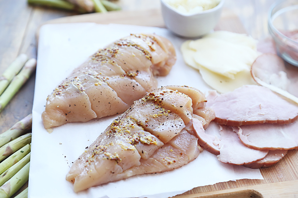 Seasoned chicken breasts sliced hasselback-style with ham and mozzarella slices alongside