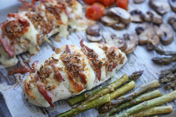Oven-browned hasselback chicken with melted mozzarella and browned pork rind crust beside roasted vegetables