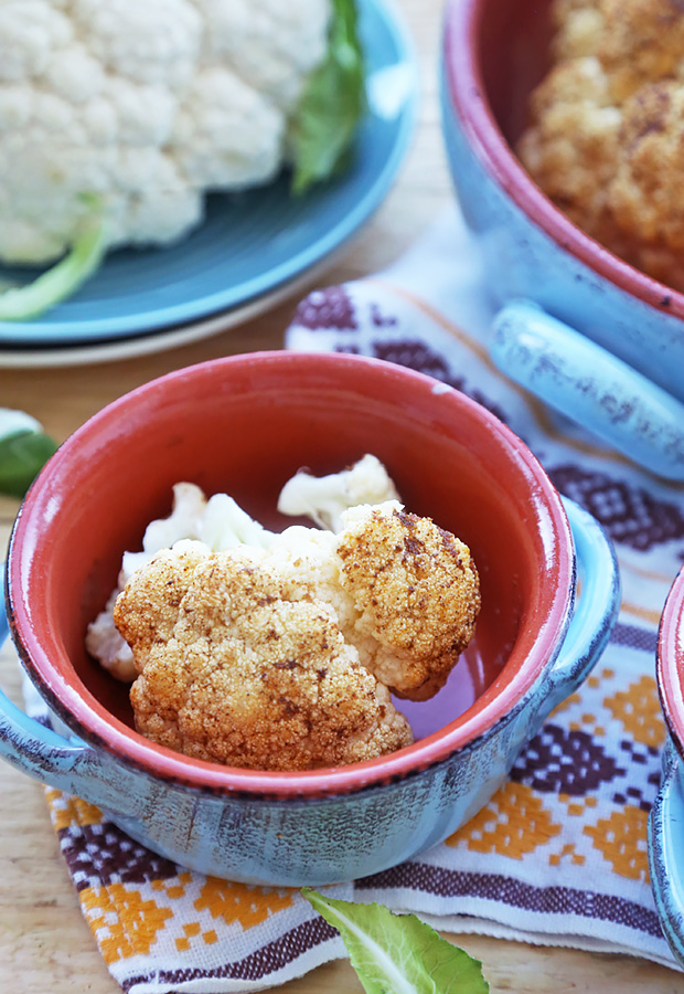 Tender roasted cauliflower pieces with cumin and chili powder crust in a serving bowl