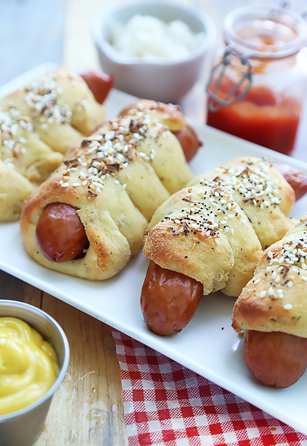 Beef hot dogs wrapped in golden fathead dough sprinkled with Everything Bagel seasoning on a platter