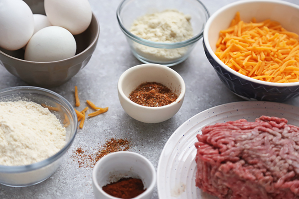Ground beef, shredded cheddar, eggs, almond flour, coconut flour, and taco seasoning in bowls