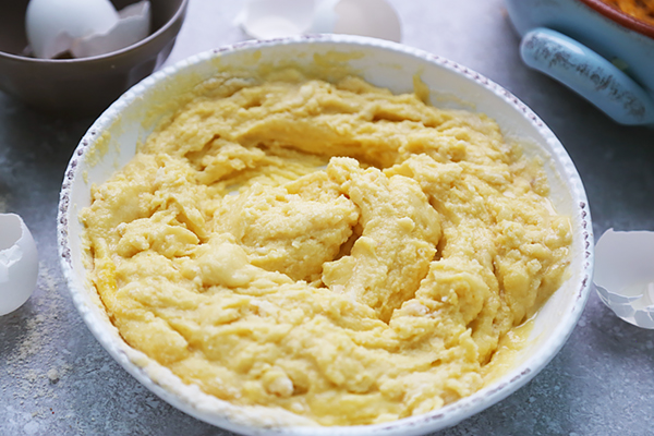 Thick yellow cornbread-style batter made with coconut flour and almond flour in a bowl
