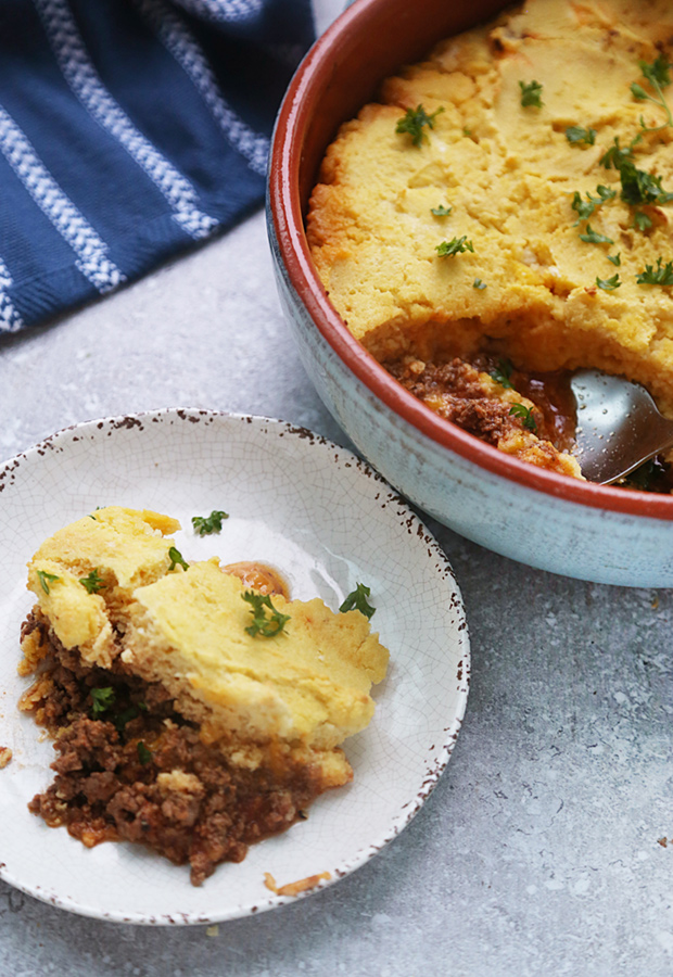 Baked tamale pie with golden crust and spiced ground beef served in a small bowl