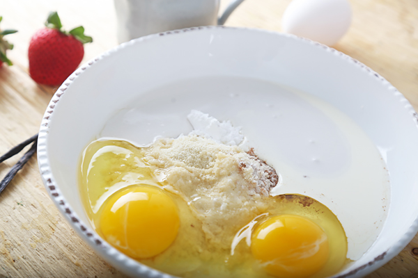 Eggs, almond flour, heavy cream, and cinnamon in a mixing bowl before whisking