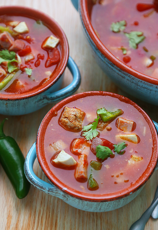 Jambalaya soup ladled into bowls with chicken, sausage, and cilantro garnish